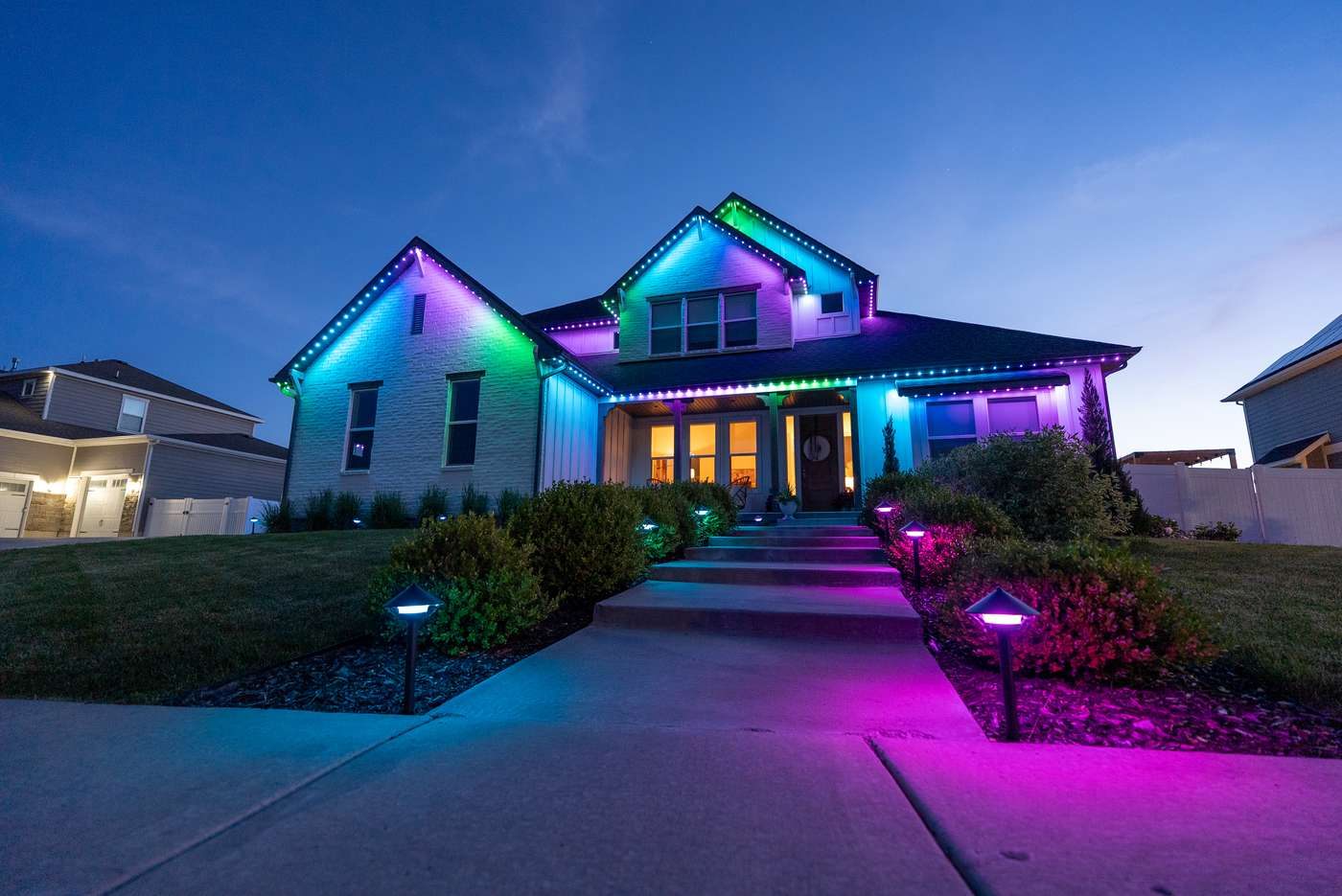 Home with blue and green roofline and purple pathway lights