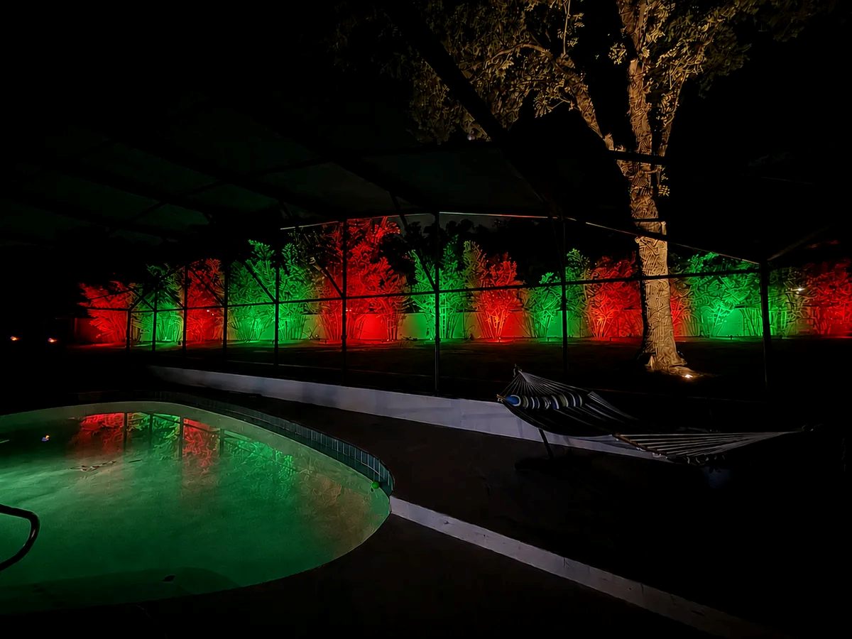 Screened pool area with the landscape lit in red and green